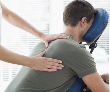 A client receiving massage while seated in a massage chair