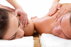 A couple lying on side-by-side massage tables