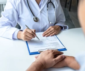 A doctor sitting across a desk from their patient. 