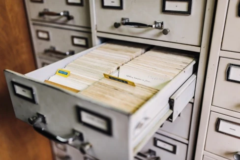 A card file cabinet with an open drawer