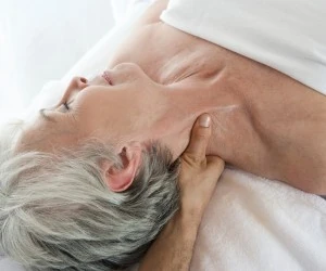 Elderly woman receiving massage therapy