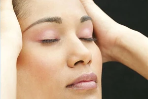 A woman with a headache massaging her temples