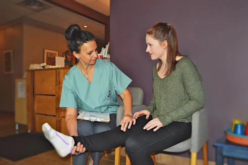 Massage therapist consulting with client in waiting room. 