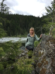 Michele Somer standing near a large rock in the outdoors.