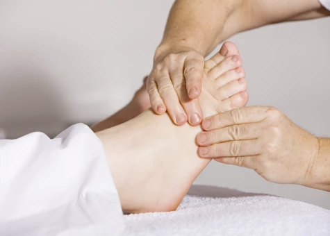 An NHPC reflexologist working on a client's foot