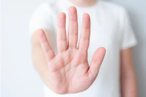 A practitioner in a white shirt holding up their hand to stop. 