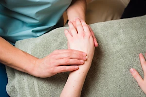 An NHPC reflexologist working on a client's wrist.