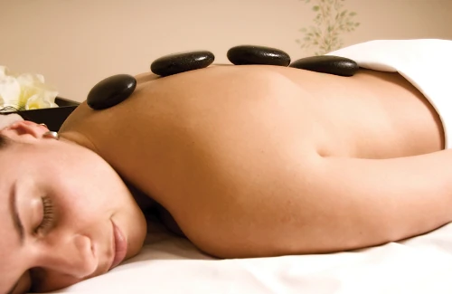 Woman with therapy stones lined up on her back