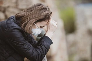 A masked person looking stressed out