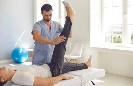 a practitioner using tuina techniques on a client's clothed leg