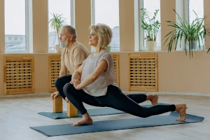 Two practitioners in a forward lunge position.